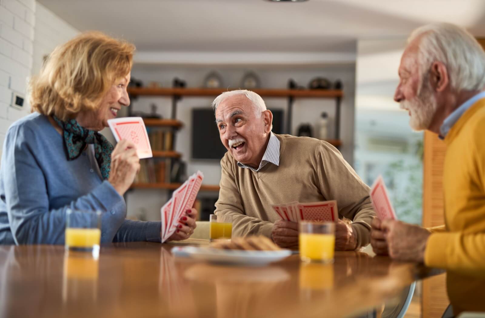 A group of seniors plays cards together in an assisted living community.