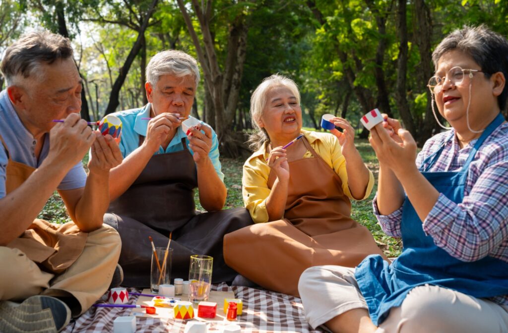 A group of seniors enjoy the outdoors and each other’s company while painting small pots for little plants